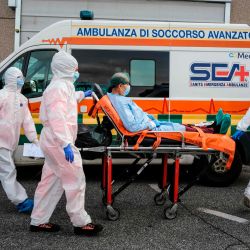Los trabajadores médicos que llevan un traje de protección llevan a un paciente en una camilla a la unidad de emergencia COVID-19 en el hospital Policlinico di Tor Vergata en Roma. | Foto:Andreas Solaro / AFP