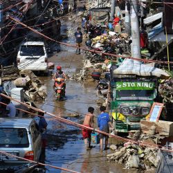 Los residentes retiran el lodo y los escombros frente a sus casas dañadas por las inundaciones en la ciudad de Marikina, en los suburbios de Manila, después de que el tifón Vamco azotara el área de la capital provocando fuertes lluvias e inundaciones. | Foto:Ted Aljibe / AFP)