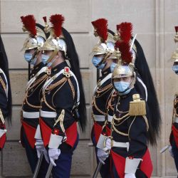 Guardias republicanos franceses, con máscaras faciales, esperan la llegada del presidente senegalés al Palacio del Elíseo en París. | Foto:Ludovic Marin / AFP