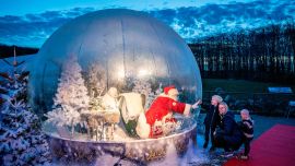 En la foto se ve a un Papá Noel en una burbuja de plástico a prueba de coronavirus en el zoológico de Aalborg.