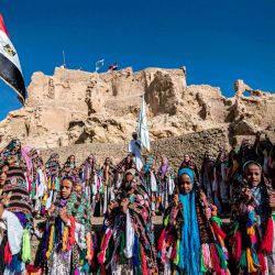 Escolares egipcios vestidos con trajes tradicionales, se reúnen durante una celebración para marcar la inauguración de la fortaleza de Shali después de su restauración, en el oasis del desierto egipcio de Siwa, a unos 600 kms al suroeste de la capital, El Cairo. | Foto:Khaled Desouki / AFP