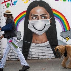 Una mujer que lleva una mascarilla pasa junto a un mural en el centro de Barcelona. - El número de muertos en España aumentó a más de 40.000 y las infecciones superaron los 1,4 millones, lo que lo convierte en el país con la cuarta tasa de mortalidad más alta de la UE. | Foto:Josep Lago / AFP