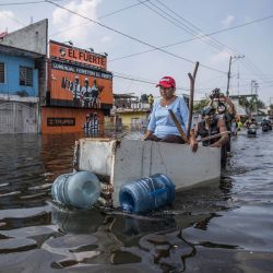 Un hombre empuja a un anciano sentado en un armario de madera en una calle inundada después de que las fuertes lluvias azotaran el estado de Tabasco. | Foto:Foto: German Espinosa / DPA