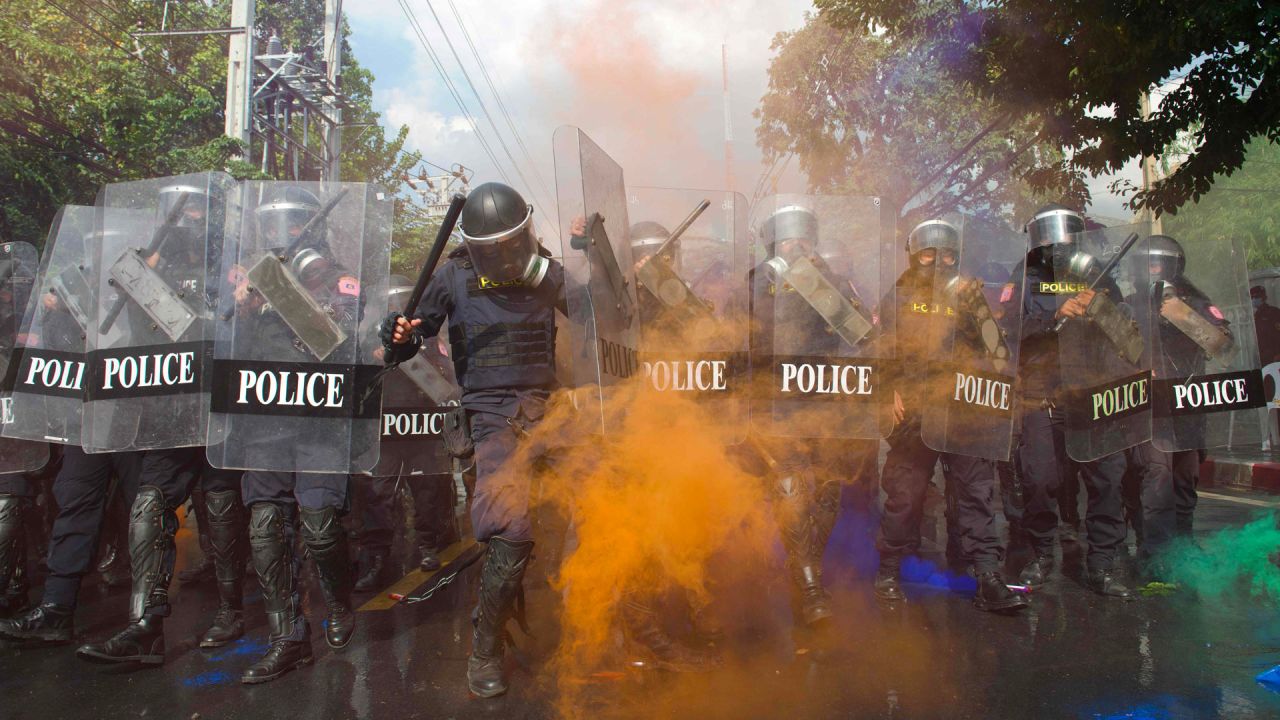 El humo naranja de una granada de humo envuelve a una fila de policías que intentan dispersar a los manifestantes a favor de la democracia durante una manifestación antigubernamental cerca del Parlamento tailandés en Bangkok. | Foto:Cory Wright / AFP