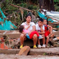 Una mujer y niños se sientan junto a su casa destruida después de que las fuertes lluvias causaron destrucción en Cúcuta, Colombia. | Foto:Schneyder Mendoza / AFP