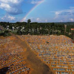 Vista aérea del cementerio reservado para las víctimas de la pandemia de COVID con un arco iris en el cielo en el cementerio de Nossa Senhora Aparecida en Manaus, en la selva amazónica de Brasil. | Foto:Michael Dantas / AFP