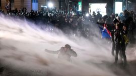 La policía rocía con un cañón de agua a los manifestantes durante una manifestación contra un proyecto de ley de