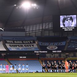 Los jugadores de ambos equipos observan un minuto de aplausos mientras presentan sus respetos al fallecido jugador de fútbol argentino Diego Maradona antes del partido de fútbol de la Premier League inglesa entre Manchester City y Burnley en el Etihad Stadium en Manchester, noroeste de Inglaterra. | Foto:Laurence Griffiths / POOL / AFP
