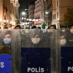 La policía antidisturbios turca mira detrás de sus escudos mientras bloquea la avenida Istiklal, la principal calle comercial de Estambul, mientras se para frente a las mujeres que marchan durante una manifestación por el Día Internacional para la Eliminación de la Violencia contra la Mujer, en Estambul. | Foto:Ozan Kose / AFP