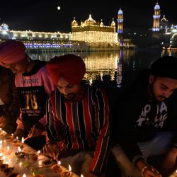 Los devotos sij encienden velas con motivo del 551 aniversario del nacimiento del fundador del sijismo Sri Guru Nanak Dev, en el Templo Dorado de Amritsar. | Foto:Narinder Nanu / AFP