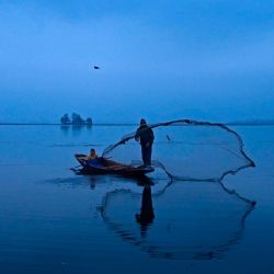 Un pescador arrojó su red en las aguas del lago Dal en Srinagar. | Foto:Tauseef Mustafa / AFP