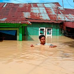 Esta fotografía muestra a un hombre saliendo de su casa inundada en Tebing Tinggi, mientras miles de casas se inundaron en el norte de Sumatra después de que lluvias torrenciales azotaran la zona. | Foto:Ahmad Putra / AFP