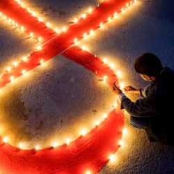 Nepal, Katmandú: una persona enciende velas con la forma de una cinta roja en vísperas del Día Mundial del SIDA. | Foto:Sunil Pradhan / DPA