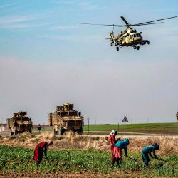 Un helicóptero militar ruso Mil Mi-17 sobrevuela un convoy de patrulla militar conjunto ruso-turco en el campo cerca de Darbasiyah a lo largo de la frontera con Turquía en la provincia nororiental de Hasakah de Siria. | Foto:Delil Souleiman / AFP
