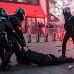 Agentes de policía arrastran a un hombre al suelo durante una protesta contra el proyecto de ley de 'seguridad global', cuyo artículo 24 penalizaría la publicación de imágenes de agentes de policía en servicio con la intención de dañar su 'integridad física o psicológica', en París. | Foto:Ameer Al-Halbi / AFP