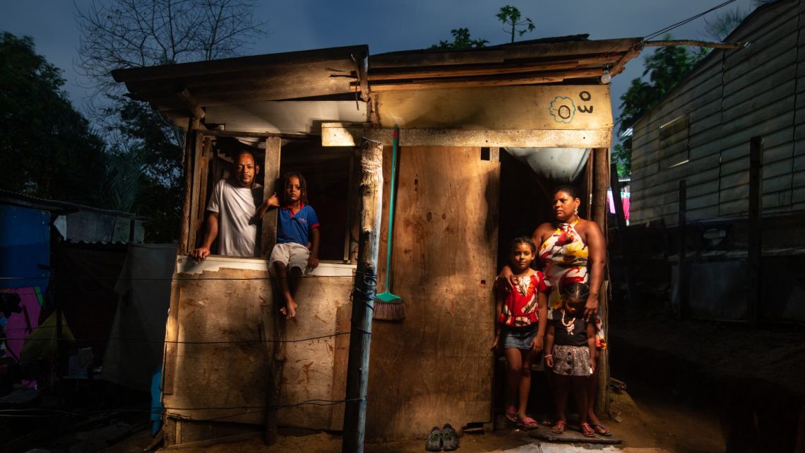 Antonio Pedro de Souza (left), 42 – a painter who has been out of work since the beginning of the pandemic – poses for a picture next to his wife (right), Ilma da Silva Santos and their children at their home at Manuel Faustino squatter camp, near Salvador, Bahía, Brazil on October 16, 2020.