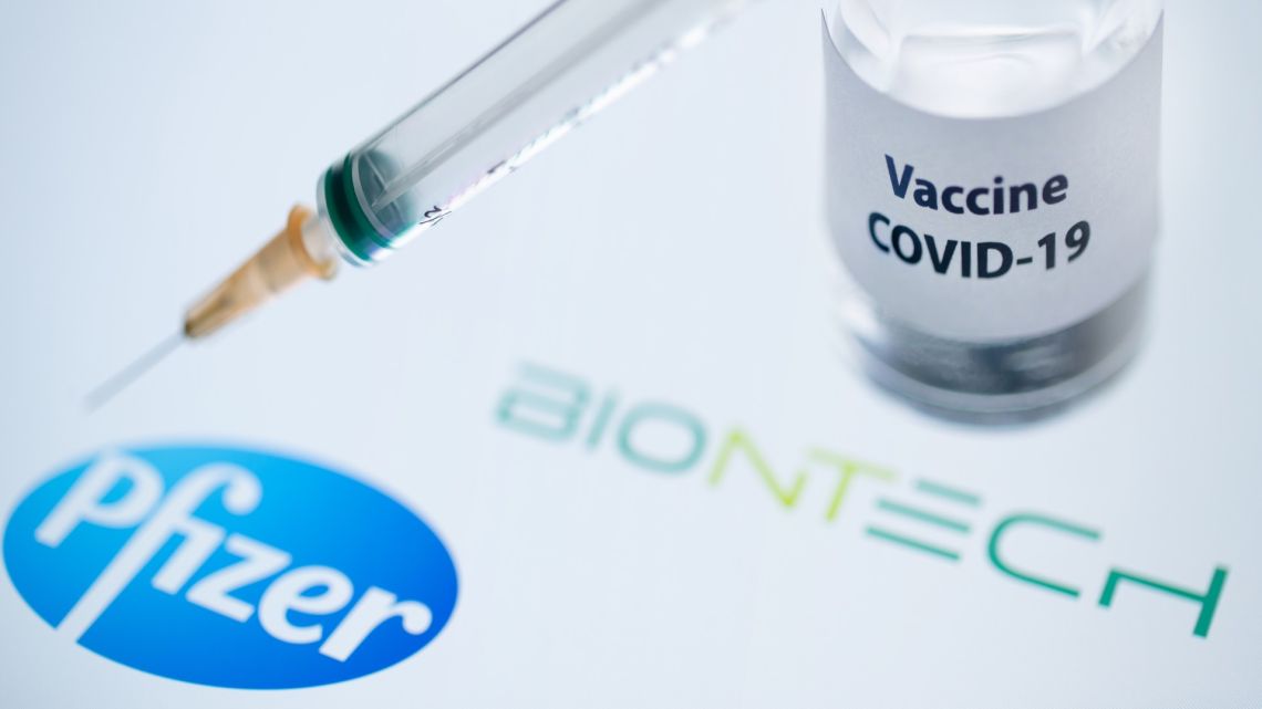 This illustration picture shows a bottle reading "Vaccine Covid-19" and a syringe next to the Pfizer and BioNtech logo. 