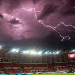 Un rayo chispas en el cielo en lo alto del estadio vacío Beira Rio en Porto Alegre, Brasil, antes del inicio del partido de fútbol a puerta cerrada de la Copa Libertadores entre el Internacional de Brasil y Boca Juniors. | Foto:Silvio Avila / AFP