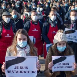 Cientos de gerentes o empleados de restaurantes, licitadores de bares o clubes, o trabajadores de eventos sostienen carteles durante una protesta contra las medidas sanitarias implementadas para frenar la pandemia Covid19, en Nantes, en el oeste de Francia. | Foto:Loic Venance / AFP