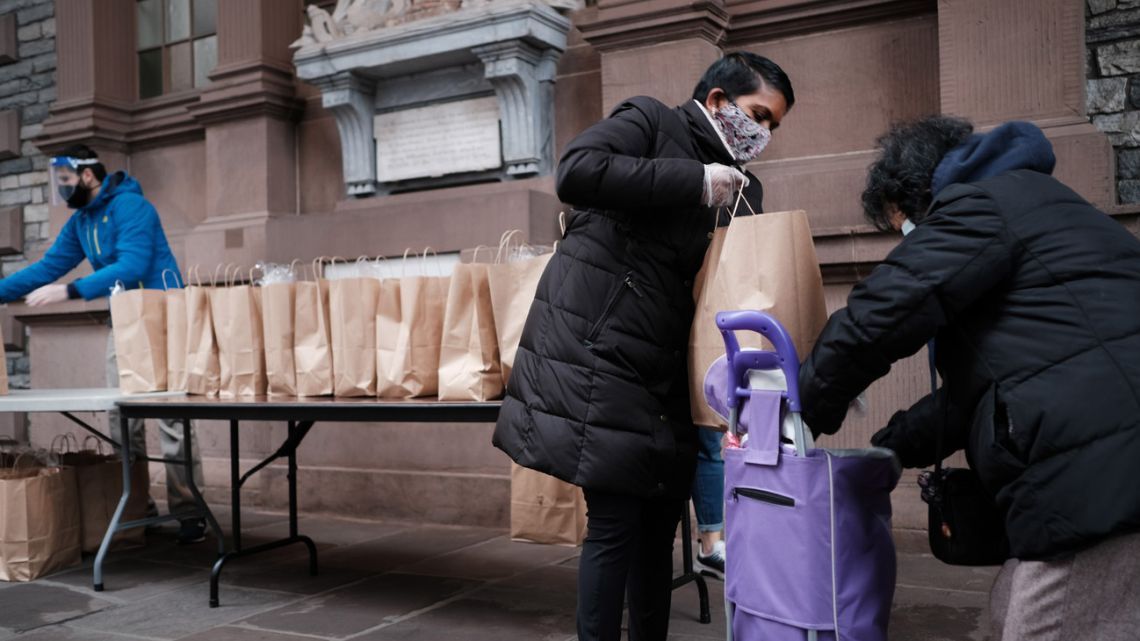 People receive bags of food at a lower Manhattan church that holds a weekly food distribution on December 02, 2020 in New York City. 