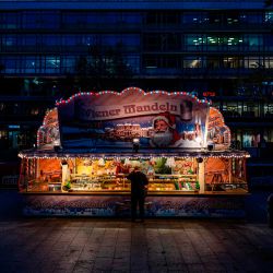 Un cliente compra especialidades navideñas en un puesto del generalmente bullicioso mercado navideño en Breitscheid platz de Berlín. | Foto:John Macdougall / AFP