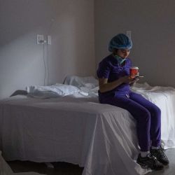 La empleada médica Anne Aguilar revisa su teléfono durante un descanso de la unidad de cuidados intensivos (UCI) COVID-19 en el United Memorial Medical Center en Houston, Texas. Texas informa más de 1.2 millones de casos positivos de Covid-19 y más de 21,800 muertes. | Foto:Nakamura / Getty Images / AFP