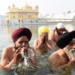 Los devotos sij se dan un chapuzón en el sagrado sarovar (tanque de agua) con motivo del 551 aniversario del nacimiento del fundador del sijismo, Sri Guru Nanak Dev, en Amritsar. | Foto:Narinder Nanu / AFP