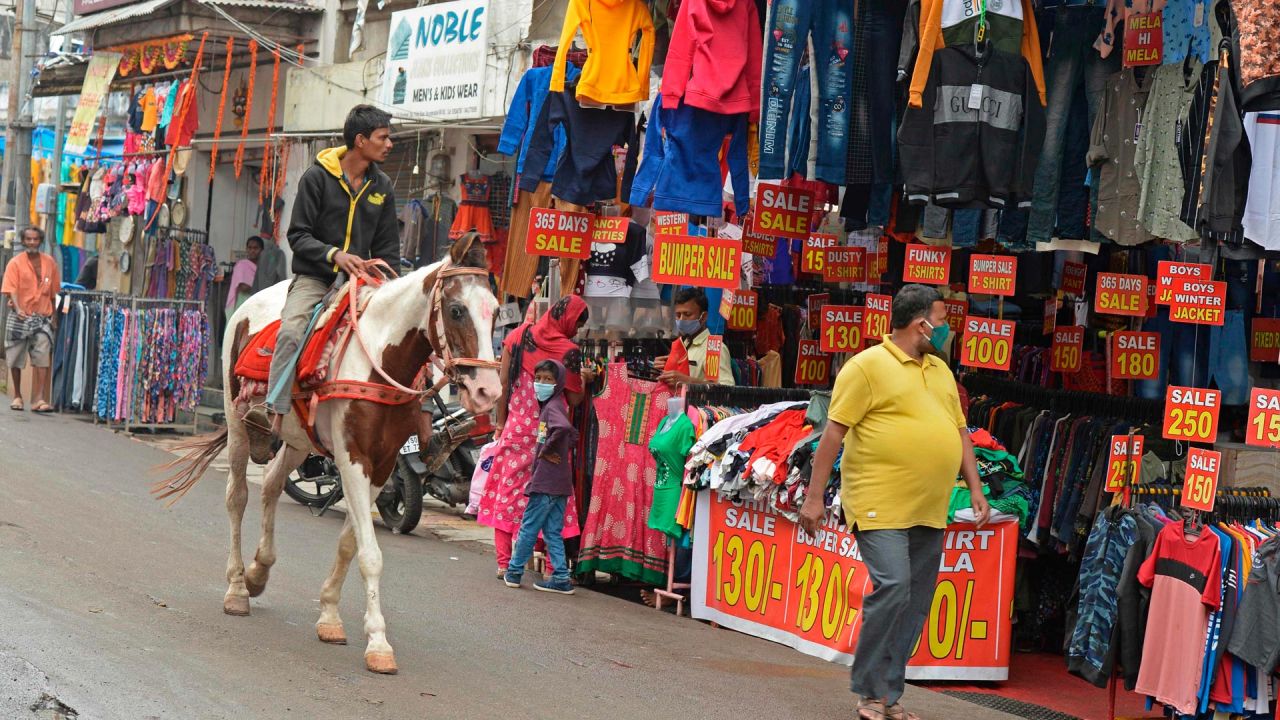 Un hombre monta a caballo por un mercado en Hyderabad. | Foto:Noah Seelam / AFP