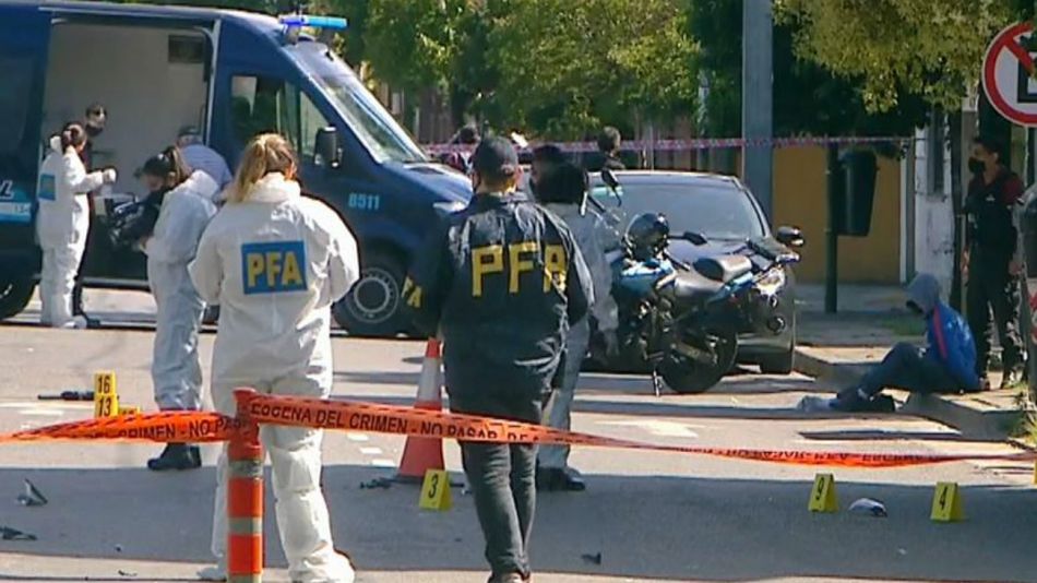 La policía trabajando en las pericias en el lugar donde fue asesinado el oficial González Sueiro. Sentado a un costado, el delincuente detenido.