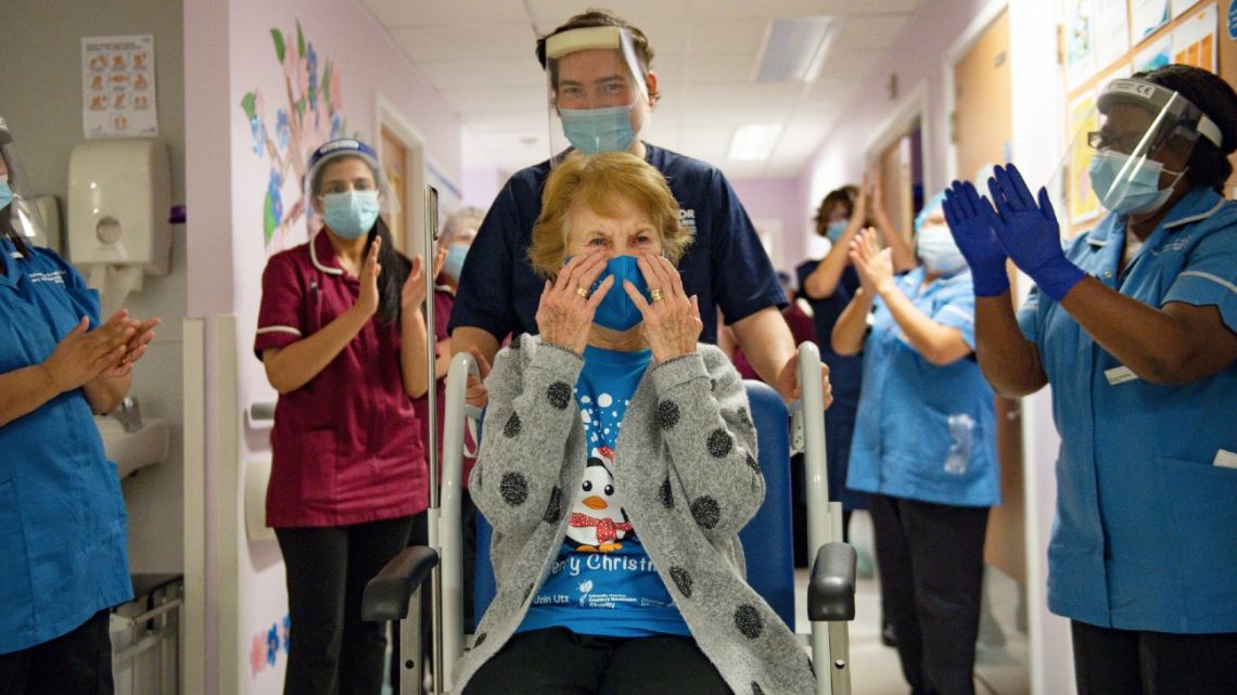 Margaret Keenan (centre), 90, is applauded by staff as she returns to her ward after becoming the first person to receive the Pfizer-BioNtech Covid-19 vaccine at University Hospital in Coventry, central England, on December 8, 2020. Britain on December 8 hailed a turning point in the fight against the coronavirus pandemic, as it begins the biggest vaccination programme in the country's history with a new Covid-19 jab. 