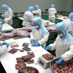 Esta foto muestra a trabajadores empacando bistec congelado para exportar en una planta de procesamiento de carne en Binzhou, en la provincia de Shandong, en el este de China. | Foto:STR / AFP