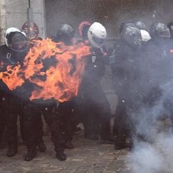 Miembros de la brigada francesa de represión de la acción violenta policías BRAV son rodeados por un incendio durante una manifestación por los 'derechos sociales' y contra el proyecto de ley de 'seguridad global', que en su artículo 24 penalizaría la publicación de imágenes de policías de guardia con la intención de dañar su 'integridad física o psicológica', en París. | Foto:Anne-Christine Poujoulat / AFP