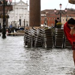 La foto muestra a una modelo sosteniendo su vestido en una plaza de San Marcos inundada luego de un evento de marea alta  | Foto:ANDREA PATTARO / AFP