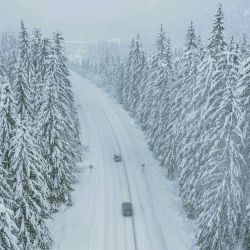 Esta vista aérea muestra automóviles conduciendo por una carretera principal en el distrito de Lienz, Tirol, mientras se acerca el invierno con fuertes nevadas. | Foto:JFK / varias fuentes / AFP