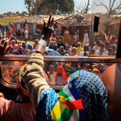 Los refugiados de la República Centroafricana saludan a través de la ventanilla de un autobús para despedirse de la gente de Gado Gado, Camerún, cuando parten de regreso a la República Centroafricana. - Los refugiados de la República Centroafricana están regresando a su país de origen desde Gado, Camerún. | Foto:AFP