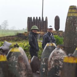 Los visitantes caminan junto a los restos de las bombas de aviones que se exhiben en el museo de la base aérea de combate Khe Sanh en la provincia de Quang Tri. | Foto:Nhac Nguyen / AFP