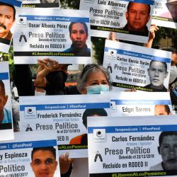 Familiares de opositores al gobierno que permanecen detenidos en diferentes cárceles sostienen carteles con sus retratos y nombres durante una protesta convocada por la ONG de derechos humanos Foro Penal en el marco de una campaña denominada  | Foto:Yuri Cortez / AFP