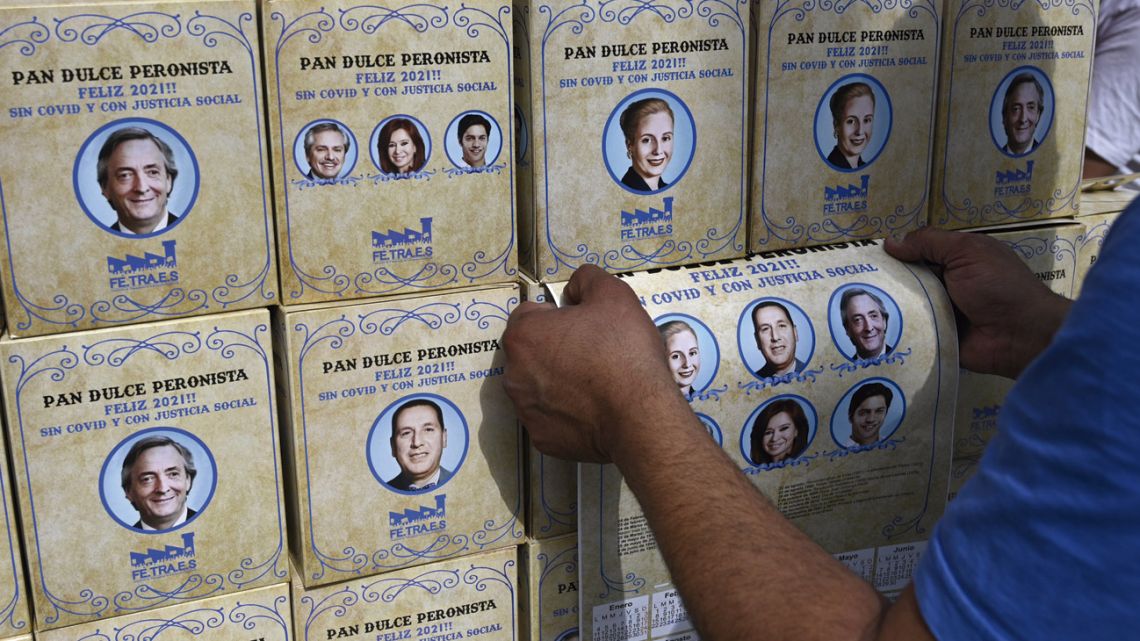Panettones pictured for sale outside Congress. The boxes read: “Peronist Panettone. Happy 2021. Without Covid and with social justice,” and depicting portraits of Peronist leaders including Juan Perón, Eva Perón, Néstor Kirchner, Cristina Fernández de Kirchner, Alberto Fernández and Axel Kiciloff.