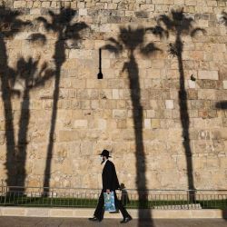 Un judío ultraortodoxo con una máscara protectora debido a la pandemia de COVID-19, camina por las murallas de la Ciudad Vieja de Jerusalén. | Foto:Emmanuel Dunand / AFP