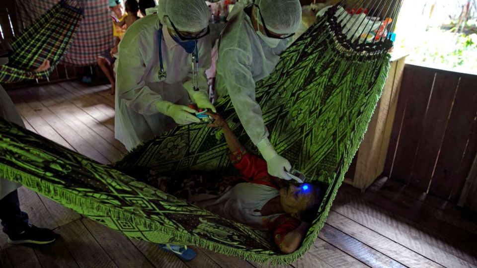 Personal sanitario atiende a un enfermo en una isla sobre el río Amazonas.