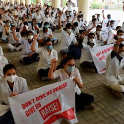 Los médicos internos gritan consignas y sostienen pancartas mientras participan en una protesta durante su huelga indefinida en demanda de un aumento del estipendio en el BJ Medical College en Ahmedabad. | Foto:SAM PANTHAKY / AFP