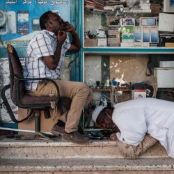 Hombres sudaneses charlan en sus teléfonos móviles en la capital, Jartum. | Foto:Yasuyoshi Chiba / AFP