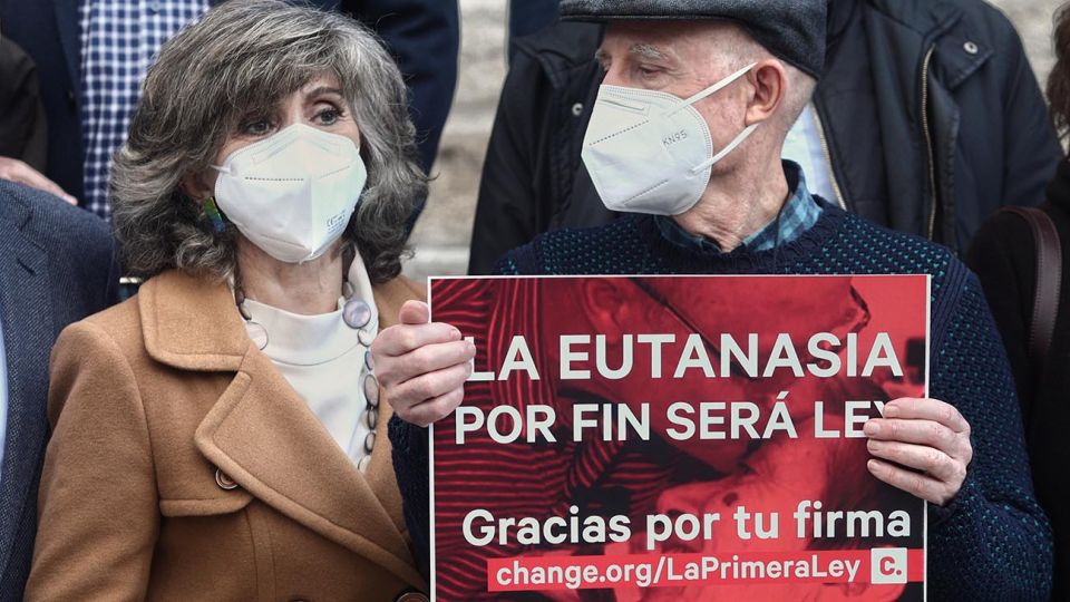 La exministra de Sanidad y actual secretaria de Sanidad de la Comisión Ejecutiva Federal del PSOE, María Luisa Carcedo (i), junto a Ángel Hernández (que ayudó a morir a su mujer, enferma de esclerosis múltiple) (d) celebran, frente al Congreso de los Diputados, la aprobación de la ley que regula la eutanasia, en Madrid (España), a 17 de diciembre de 2020. El Pleno del Congreso ha aprobado este jueves la Ley Orgánica para la regulación de la Eutanasia, con los únicos votos en contra de PP y Vox. El texto ha contado, así, con el apoyo del 56% de la Cámara (198 votos a favor, 138 en contra y dos abstenciones) y ahora continuará con su tramitación en el Senado.