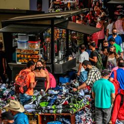 La gente camina mientras los vendedores ambulantes interactúan con los clientes en medio de la pandemia de Covid-19, en una calle de Medellín, Colombia. | Foto:Joaquin Sarmiento / AFP
