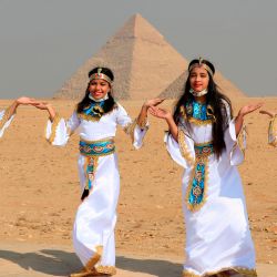 Chicas egipcias posan con trajes de faraón frente a las pirámides de Giza en las afueras al suroeste de la capital egipcia, El Cairo. | Foto:Khaled Desouki / AFP