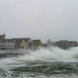 Las olas rompen cerca de las casas junto a la costa cuando la marea alta y el viento causaron una gran marejada durante una tormenta invernal en Scituate, Massachusetts. | Foto:Joseph Prezioso / AFP