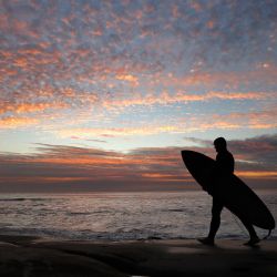Estados Unidos, San Diego: un surfista sale del agua durante la puesta de sol en la playa de Windansea en el barrio de La Jolla. | Foto:K.C. Alfred / ZUMA Wire / DPA