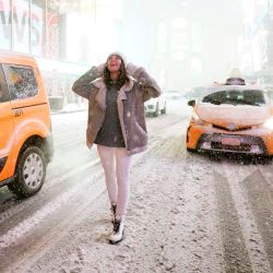 Un turista se encuentra bajo la nieve en Times Square cuando la tormenta Gail golpea la costa este. - El área de los tres estados se está preparando para una gran tormenta de nieve. | Foto:Timothy A. Clary / AFP