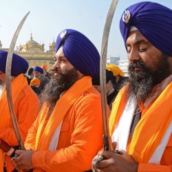 Los hombres santos sij conocidos como 'Panj Pyare' sostienen espadas durante una procesión religiosa en la víspera del día del martirio del noveno Sikh Guru Tegh Bahadur en el Templo Dorado en Amritsar. | Foto:Narinder Nanu / AFP