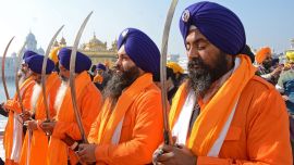 Los hombres santos sij conocidos como 'Panj Pyare' sostienen espadas durante una procesión religiosa en la víspera del día del martirio del noveno Sikh Guru Tegh Bahadur en el Templo Dorado en Amritsar.